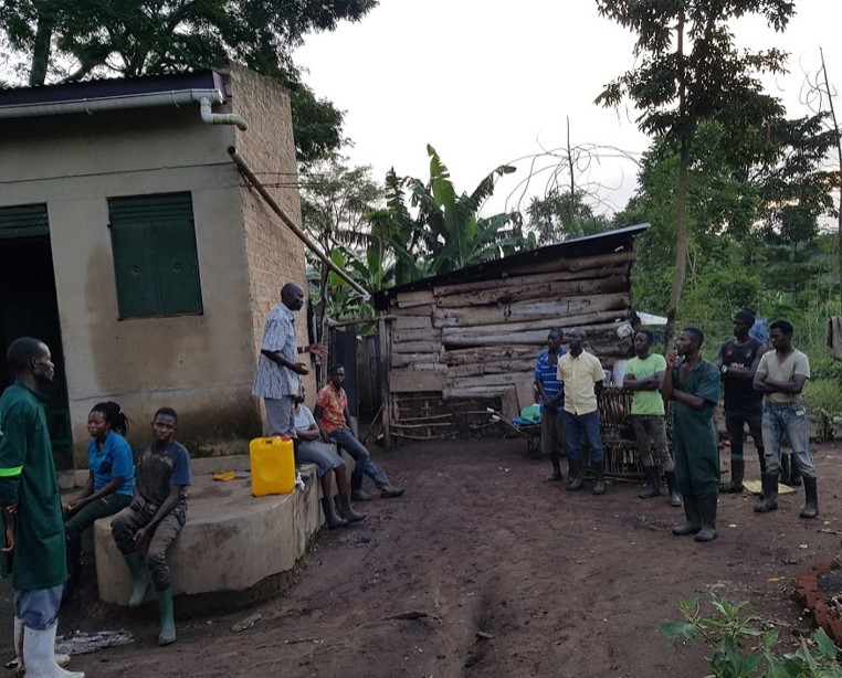 a group of young people listening to a lecture in a village in Uganda